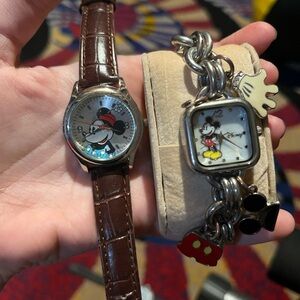 Two disney watches one with charm bracelet band and the other with leather